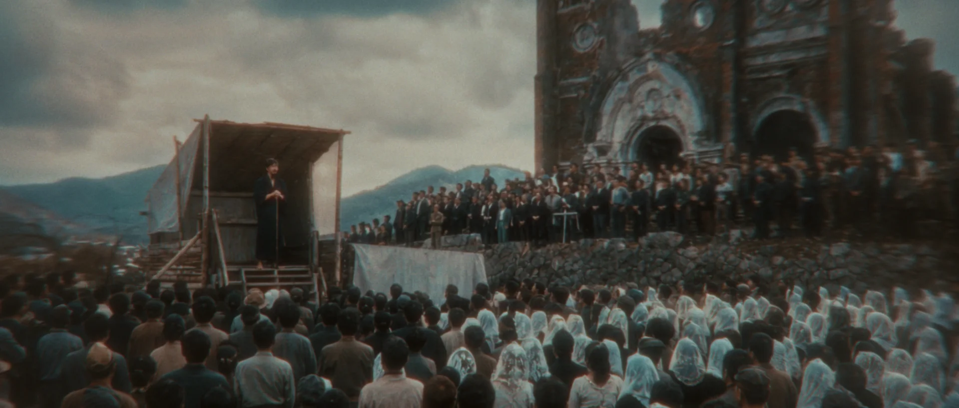 A crowd gathered before the ruined cathedral